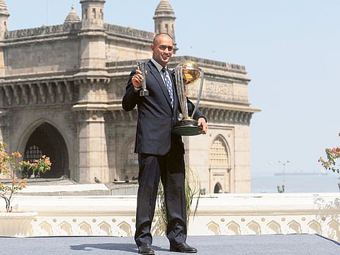 The morning after: A shaven-headed Mahendra Singh Dhoni poses with the ICC World Cup and the Man-of-the-Match award near the Gateway of India in Mumbai in 2011.