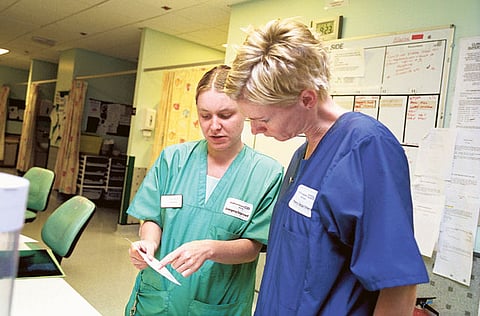 Two NHS staff members consult at a UK hospital. Photo for illustrative purposes only.