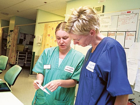 Two NHS staff members consult at a UK hospital. Photo for illustrative purposes only.