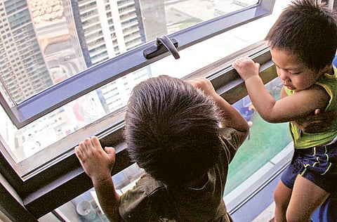 Unlocked windows in high rise buildings are a threat to unsupervised children who often play around them and meet with fatal falls. This photograph was taken under adult supervision. 