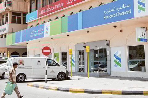 A man walks past a Standard Chartered Bank in Sharjah.
