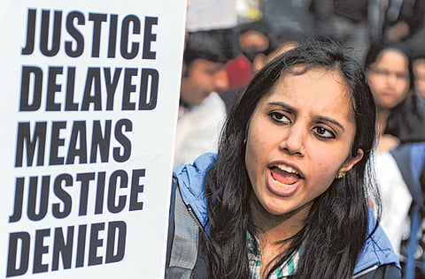 A demonstrator holds a placard as she shouts slogans during a protest calling for better safety for women. (File photo)