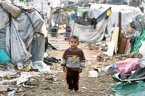 An impoverished boy walks amidst shacks and rubbish (File image)