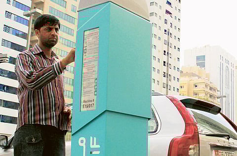 A man paying his parking fee in Abu Dhabi