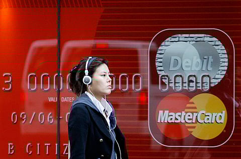 A woman walks past a Mastercard advertisement in central Sydney.