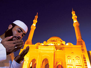 A man praying outside Al Noor Mosque in Sharjah 
