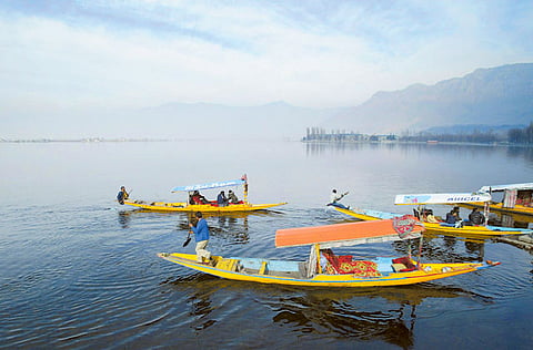 Kashmiri boatmen row their Shikara, a small boat, as tourists enjoy a ride in Dal Lake in  Srinagar. (File photo) 
