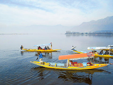 Kashmiri boatmen row their Shikara, a small boat, as tourists enjoy a ride in Dal Lake in  Srinagar. (File photo) 