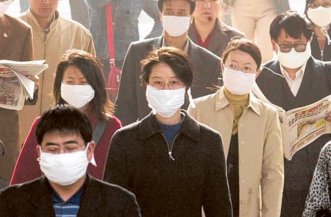 Chinese go to work at the height of the SARS scare. The WHO has warned against a new SARS-like virus.