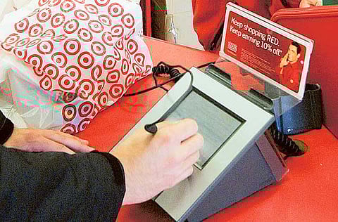 File picture of a customer signing his credit card receipt at a Target store in Tallahassee, Florida. But a good number of US shoppers still prefer the paper version. 