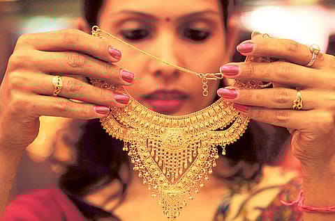 A salesgirl shows a gold necklace to customers at a jewellery showroom in the northern Indian
city of Chandigarh