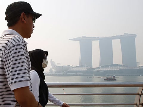 File picture of a tourist passing the Marina Bay Sands casino and resort in Singapore. 