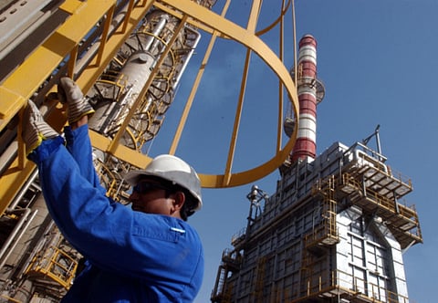 An oil technician climbs down a tower at a refinery in Jebel Ali.  Organization of Petroleum Exporting Countries (OPEC) partners did manage to scurry up a historic deal in recent days, but the question on investor minds is why hasn’t the move targeted at stabilizing oil prices worked its magic yet.