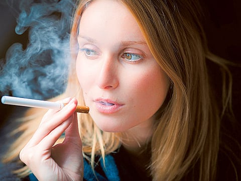 A woman exhales after ‘vaping’. There is now even a vaping lexicon, according to Oxford Dictionaries, with coinages including vape pen and vape shop and e-juice.