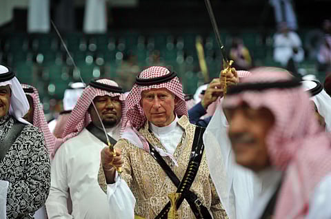 This file 2014 pictures shows Britain's Prince Charles (C) wearing traditional Saudi uniform, dancing with sword during the traditional Saudi dancing best known as 'Arda' performed during Janadriya culture festival at Der'iya in Riyadh. 
