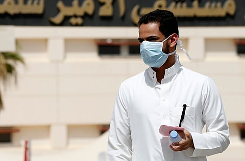 A man wearing a mask walks outside Prince Salman bin Abdulaziz hospital, in Riyadh.