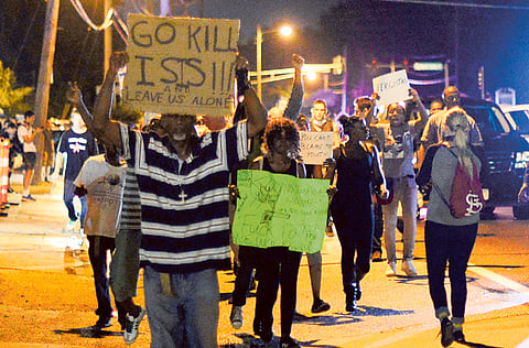 epa04361935 Demonstrators walk along the street while protesting the shooting death of Michael Brown