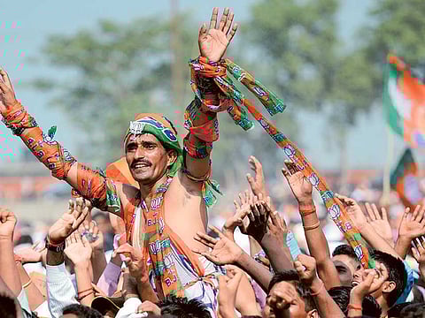 BJP supporters cheer as Modi delivers a speech during an election rally (File) 