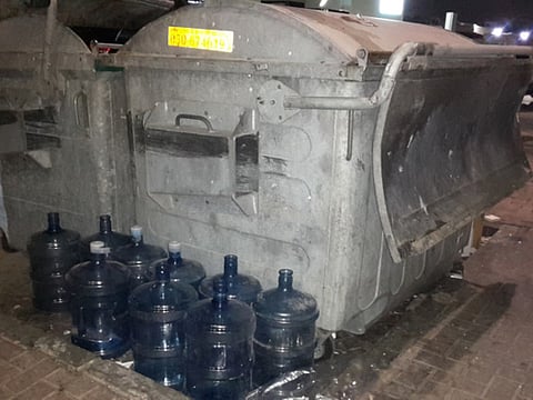 Water bottles placed next to garbage bin