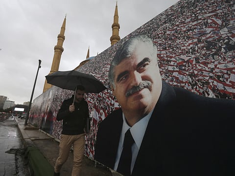 A Lebanese man walks by a giant poster of slain former Lebanese Prime Minister Rafik Hariri 