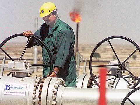 A worker of Kuwait Oil Company adjusts the flow of crude oil into a gathering centre. The cost of oil extraction is relatively less for the UAE, Saudi Arabia and Kuwait, where it is below the $16 per barrel mark.