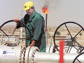 A worker of Kuwait Oil Company adjusts the flow of crude oil into a gathering centre.