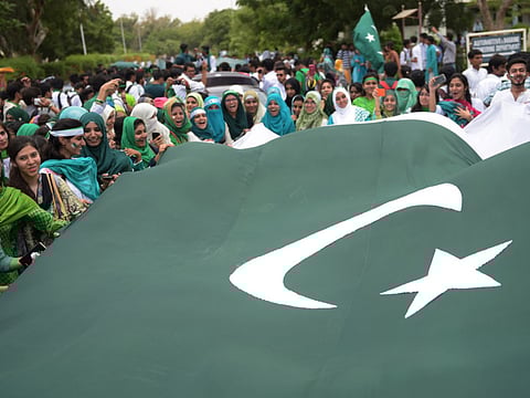 File picture: Pakistani students carry a national flag as they march on a street ahead of the country's Independence Day celebrations in Karachi on August 13, 2015. 