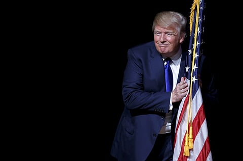Donald Trump hugs a US flag in Derry, New Hampshire (File) 