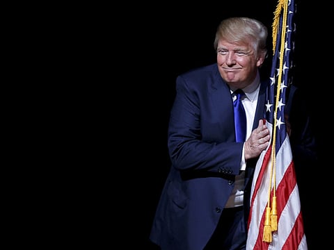 Donald Trump hugs a US flag in Derry, New Hampshire (File) 