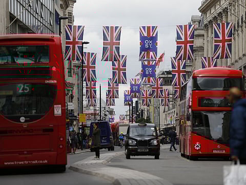 The Union Jack flutters on Oxford Street in central London.  Fitch ratings on Friday maintained Britain's AA- debt rating and outlook at negative.