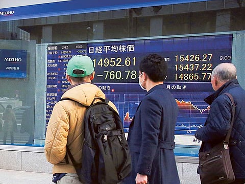 People look at an electronic stock board of a securities firm in Tokyo.
