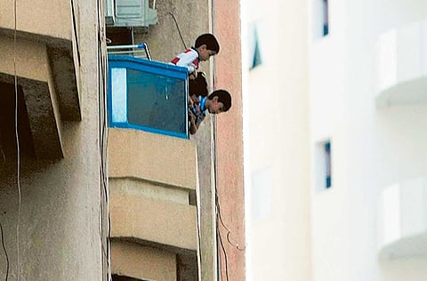 Kids leaning dangerously from balcony of an apartment in Al Nahda, Sharjah. For illustrative purposes only.