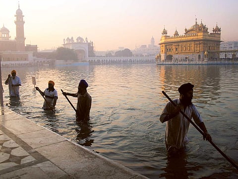 In this file photo, Sikh devotees clean the tank at the Golden Temple in the morning.  