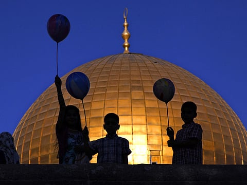 Palestinian children hold balloons near the Dome of the Rock Mosque in the Al Aqsa Mosque compound in Jerusalem's Old City. 