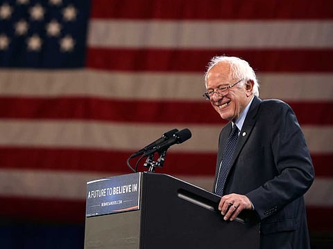 Democratic presidential candidate, Senator Bernie Sanders, reacts to a fist-waving supporter as he speaks at a campaign rally.