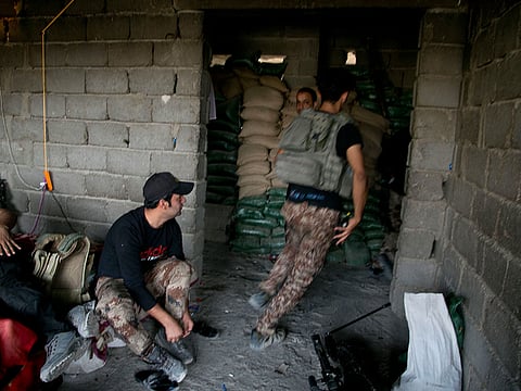 A soldier from Iraq's elite counterterrorism forces rushes to respond to sniper fire. A machine gun attack on a remote northern Iraqi military post killed four soldiers.