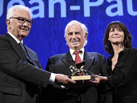 File photo: French actor Jean-Paul Belmondo, centre, holds his Golden Lion for Lifetime Achievement award, next to Biennale President Paolo Baratta, left, and actress Sophie Marceau, during the 73rd annual Venice International Film Festival, in Venice, Italy, Thursday, September 8, 2016. 