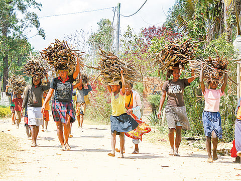 Poor villagers carry firewood on their heads in Antsibrabe, Madagascar.