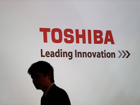 A man walks past the logo of Toshiba Corp. displayed at the company's headquarters in Tokyo on February 14, 2017.