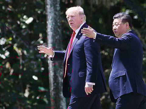 A file photo of US President Donald Trump and China’s President Xi Jinping stroll through the Mar-a-Lago estate.  Trump and Chinese Vice Premier Liu He are expected to sign a Phase 1 deal that will roll back some tariffs