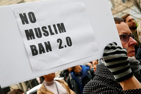 A protester displays a placard against US President Donald Trump's travel ban on Muslims.  