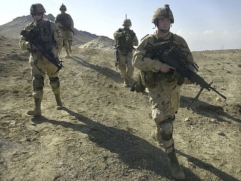 File photo: US soldiers patrol the perimeter of a weapons cache four miles of the US military base in Bagram, Afghanistan. For the United States and its coalition partners, the endgame is murky.  
