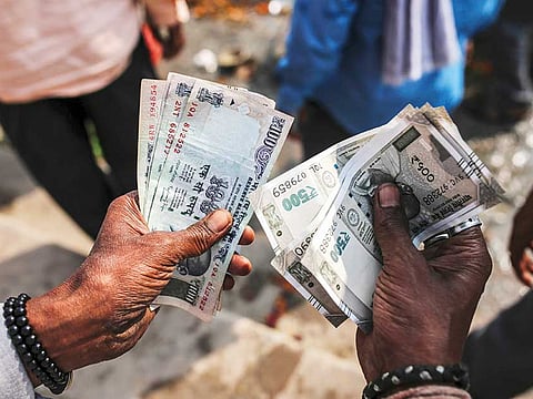 A man counts Indian rupee banknotes in an arranged photograph in Varanasi, Uttar Pradesh, India.