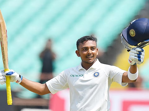 India's Prithvi Shaw celebrates after scoring a century during the first Test match against West Indies at the Saurashtra Cricket Association stadium in Rajkot on October 4, 2018. 