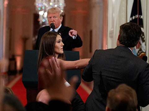 President Donald Trump looks on as a White House aide takes away a microphone from CNN journalist Jim Acosta during a news conference in the East Room of the White House, Wednesday, Nov. 7, 2018, in Washington.
