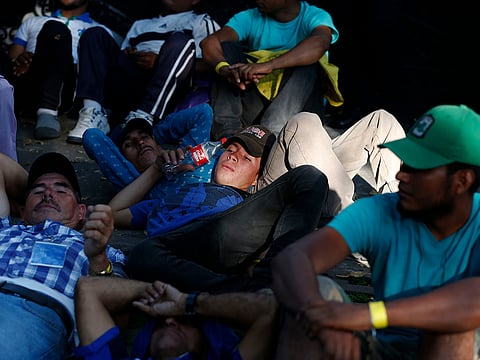Scores of Central American migrants, representing the thousands participating in a caravan trying to reach the U.S. border, rest in front of the office of the United Nation's human rights body, after undertaking an hours-long march to demand buses, in Mexico City, Thursday, Nov. 8, 2018.