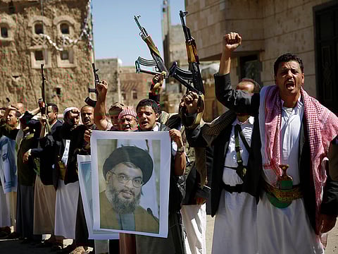 Yemen's A Houthi militiamen hold a poster of Hezbollah leader Hassan Nasrallah during a rally in support of Hezbollah, in Sana'a, Yemen. Both Al Houthis and Hezbollah get their funding from Iran. 