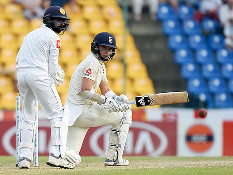 England's Sam Curran plays a shot as Sri Lanka's wicketkeeper Niroshan Dickwella (L) looks on during the first day of the second Test match between Sri Lanka and England at the Pallekele International Cricket Stadium in Kandy on November 14, 2018. 