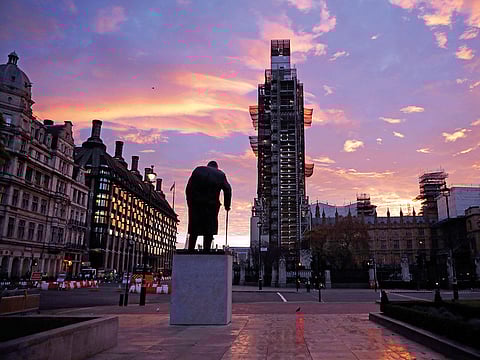 The sun rises as seen in Parliament Square with the statue of former Prime Minister Winston Churchill in the foreground in London