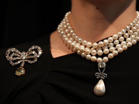 A model wears the 'Queen Marie Antoinette's Pearl' on Queen Marie Antoinette's pearl and diamond necklace, together with Queen Marie Antoinette's diamond brooch.